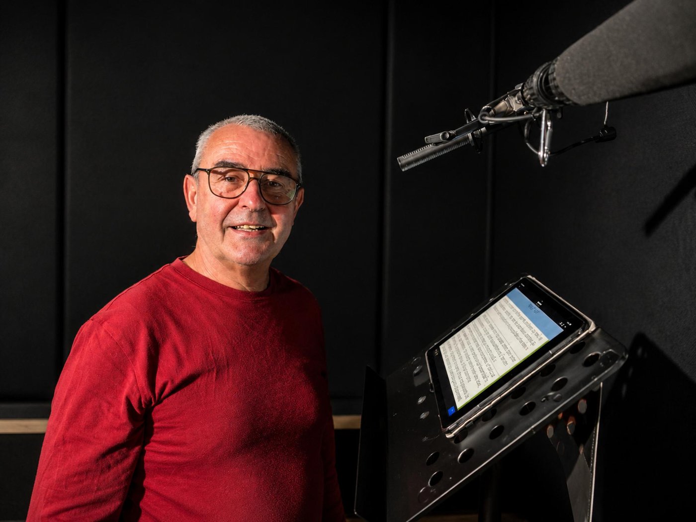 A voice talent beside a script tablet and microphone